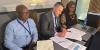 Geci and Themba signing the agreement with CLM Dean, Professor Jason Cohen