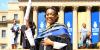 WSG graduate holding standing in front of Great Hall