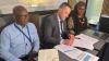 Geci and Themba signing the agreement with CLM Dean, Professor Jason Cohen